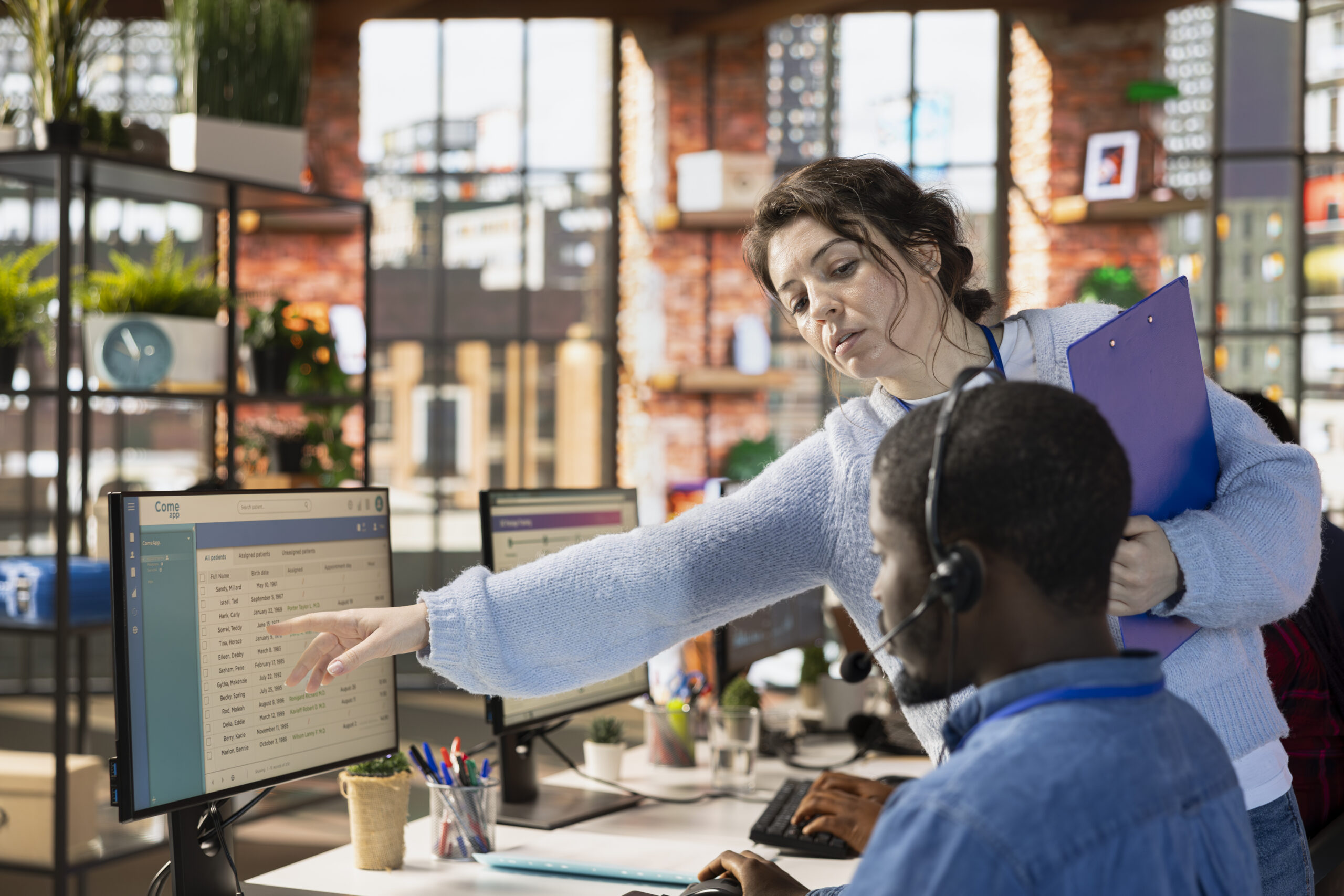 Manager guiding call center agent on CRM system
