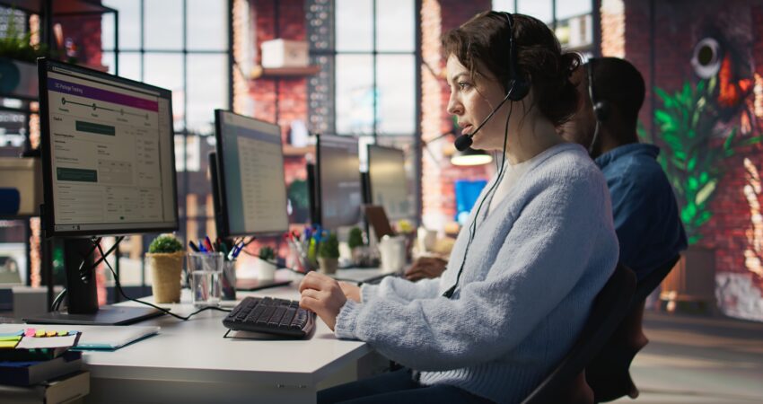 Call center agent assisting customers with support services at a modern office.