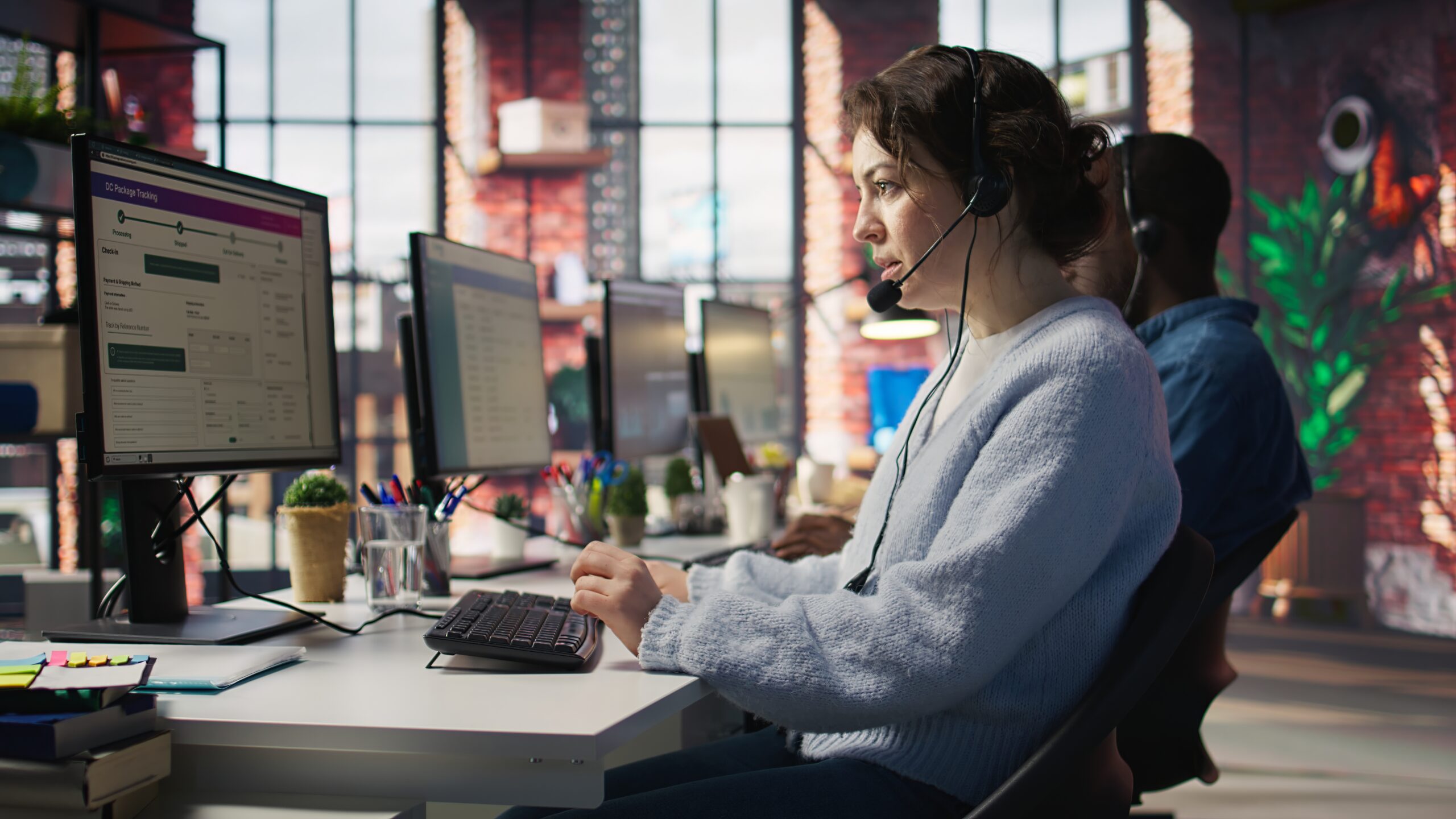 Call center agent assisting customers with support services at a modern office.